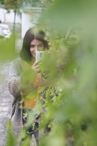 Young woman holding plant