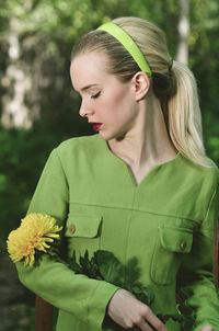 Young woman with flower standing outdoors