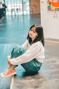 Side view of girl sitting on floor