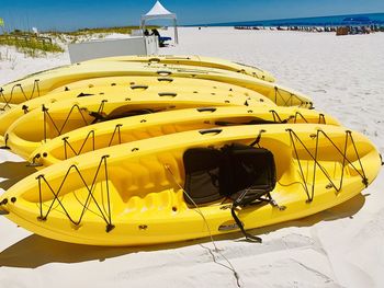 Bright yellow kayaks resting on the sandy beach