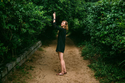 Portrait of young woman standing on dirt road