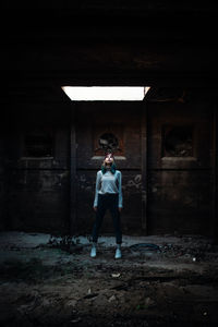 Full length of woman standing in abandoned building