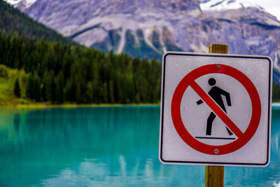 Close-up of road sign by lake