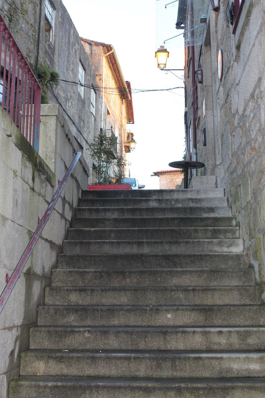 LOW ANGLE VIEW OF STAIRCASE BY BUILDING AGAINST SKY