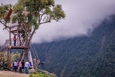 People by plants against mountain