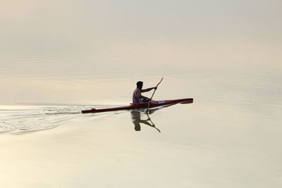 Side view of boating in calm lake