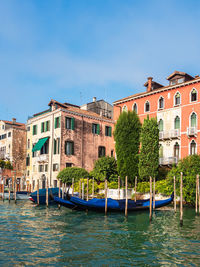 Canal by buildings against blue sky