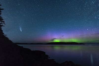 Scenic view of lake against sky at night