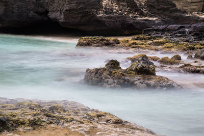 Scenic view of rocks in sea against sky