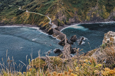 High angle view of water flowing through rocks by sea