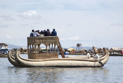 People on boat against sky