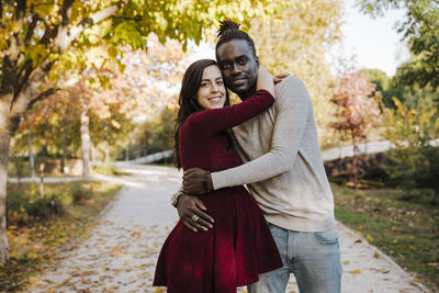 Portrait of smiling young woman standing outdoors during autumn