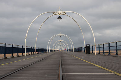 View of southport pier tramway against cloudy sky