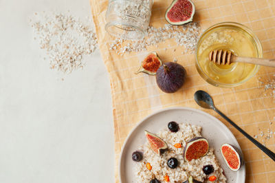 Healthy vitamin breakfast, oatmeal porridge, blueberries, fresh figs and sea buckthorn 