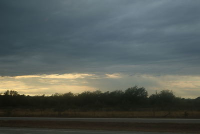 Scenic view of field against cloudy sky