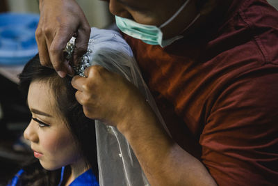 Hairdresser adjusting veil of bride