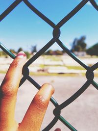 Close-up of hand on chainlink fence