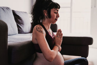 Pregnant woman exercising while sitting at home