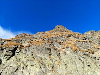 Low angle view of rock formations against blue sky