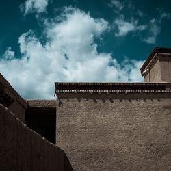 Low angle view of building against cloudy sky