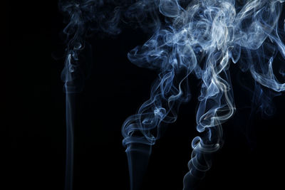 Close-up of smoke emitting over black background