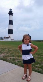 Full length of children standing by lighthouse against sky