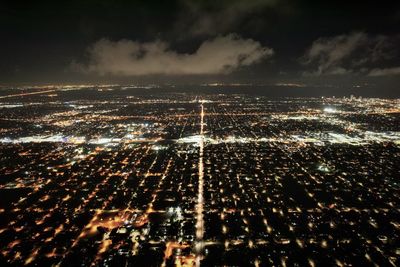 Aerial view of illuminated city against sky at night