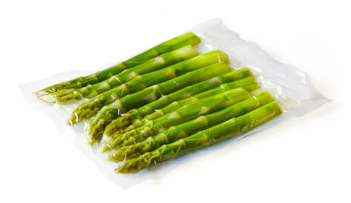 High angle view of vegetables in plate against white background