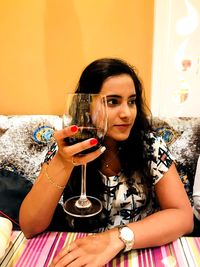 Portrait of woman drinking glass at home