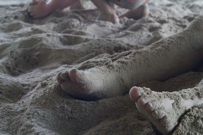 Low section of person relaxing on sand