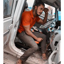 Young man sitting in car