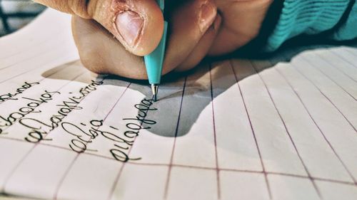 Close-up of human hand on book