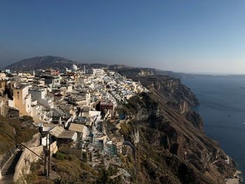 High angle view of townscape by sea against clear sky