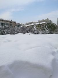 Snow covered cityscape against sky