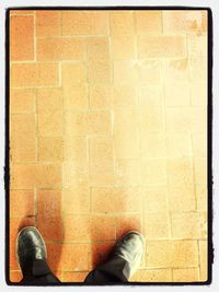 Low section of person standing on tiled floor