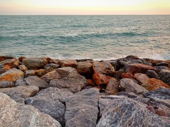 Rocks in sea against sky