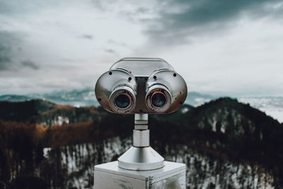 Close-up of coin-operated binoculars against sea