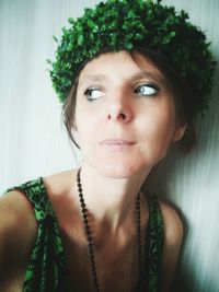 Close-up of woman looking away while wearing wreath at home