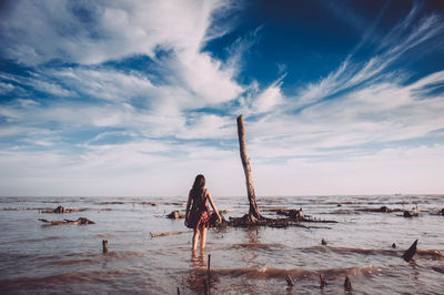 Scenic view of beach against cloudy sky