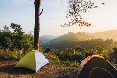 Tent on field by mountains against sky