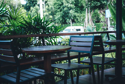 Empty chairs and table against trees