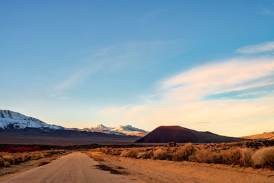 Road leading towards desert against sky