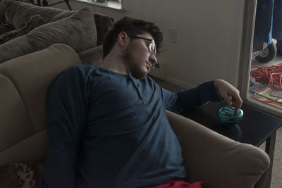 Man sitting on sofa at home