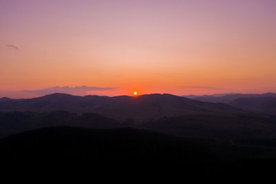 Scenic view of silhouette mountains against sky during sunset