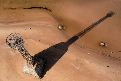 Abandoned ruins of kurmrags lighthouse on the baltic coast, aerial view, long shadow on a sunny day