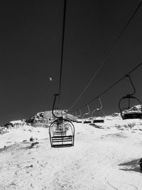 Overhead cable car on snow covered land against sky