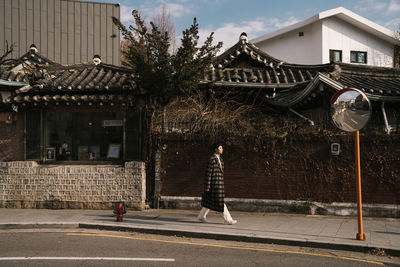 Man walking on sidewalk against buildings