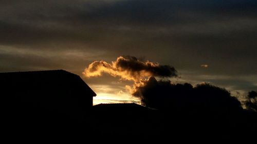 Silhouette of building against cloudy sky