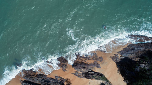 High angle view of waves splashing on rocks