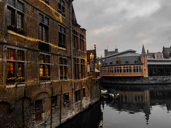 Reflection of buildings in canal against sky